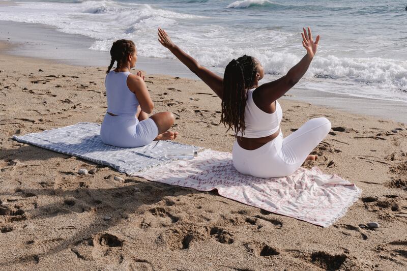 Mujeres meditando en la playa.