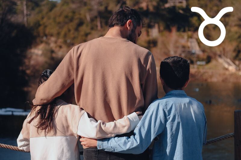 Se observa la espalda de un papa con sus dos hijos pequeños.