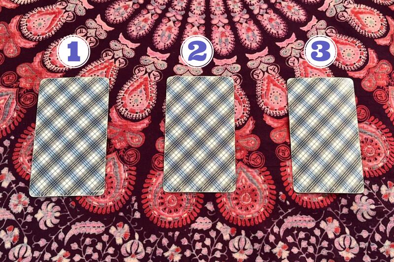 Cartas del Tarot ocultas boca abajo sobre una tela.