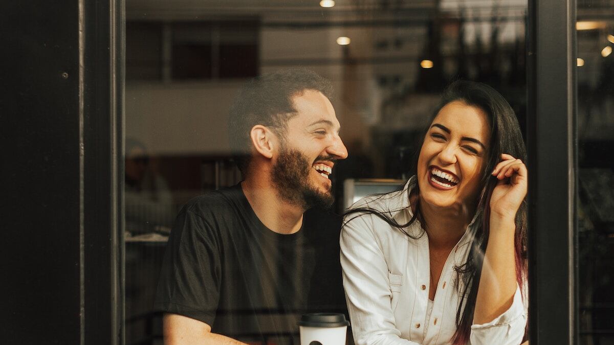 pareja riéndo en una cafetería.