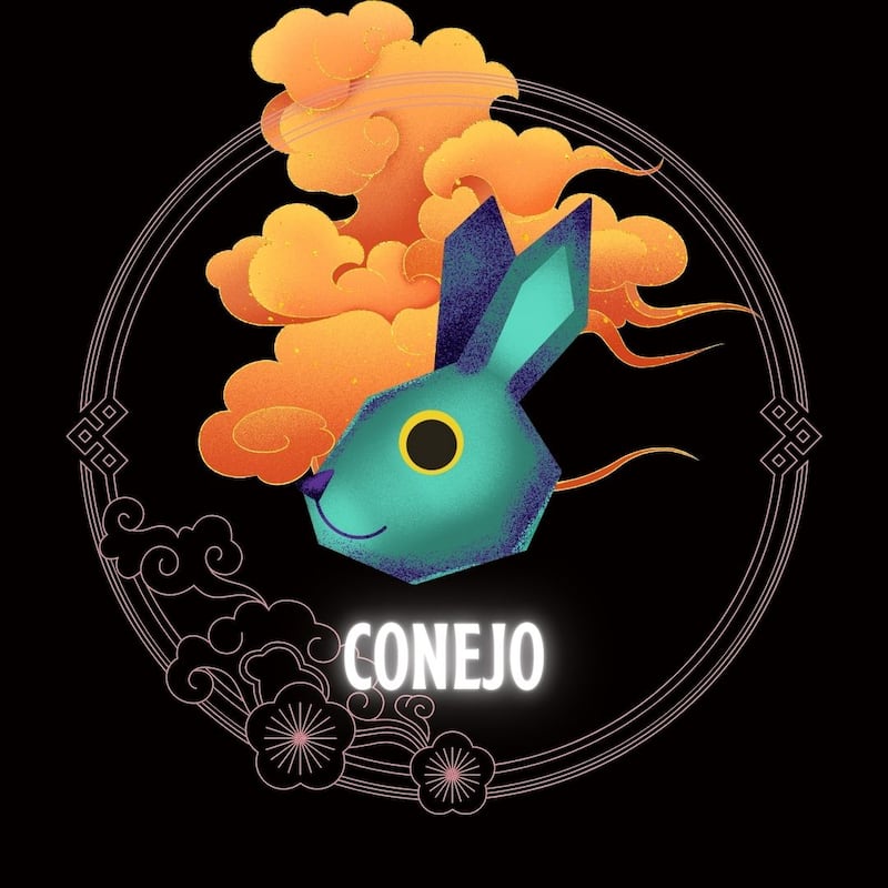 Caricatura de la cara de un conejo sobre un fondo negro azulado, enmarcado en un círculo con flores. Atrás del animal se ven nubes doradas como adornos orientales.