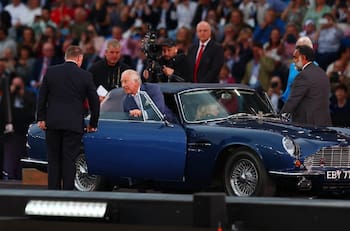 Príncipe Carlos hace una entrada triunfal manejando su Aston Martin que funciona con vino y queso