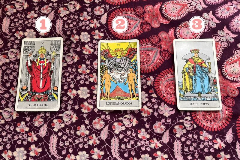 Tres cartas del Tarot reveladas sobre una tela.