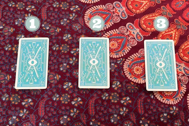 Hay tres cartas del Tarot encima de una tela.