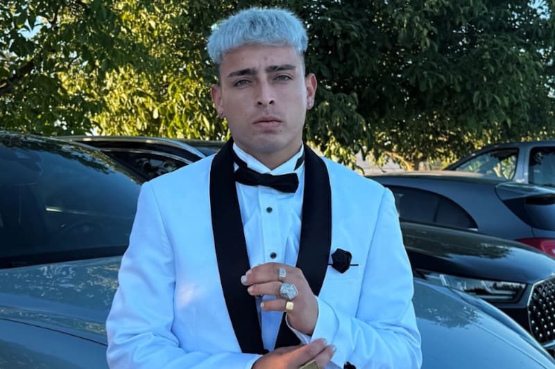 El artista urbano y su poderoso auto de lujo.