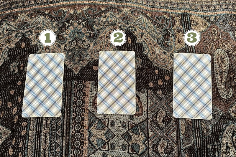 cartas del tarot ocultas sobre un mantel.