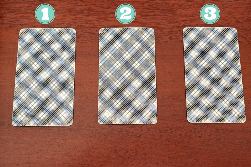 Tres cartas del Tarot escondidas encima de una mesa.