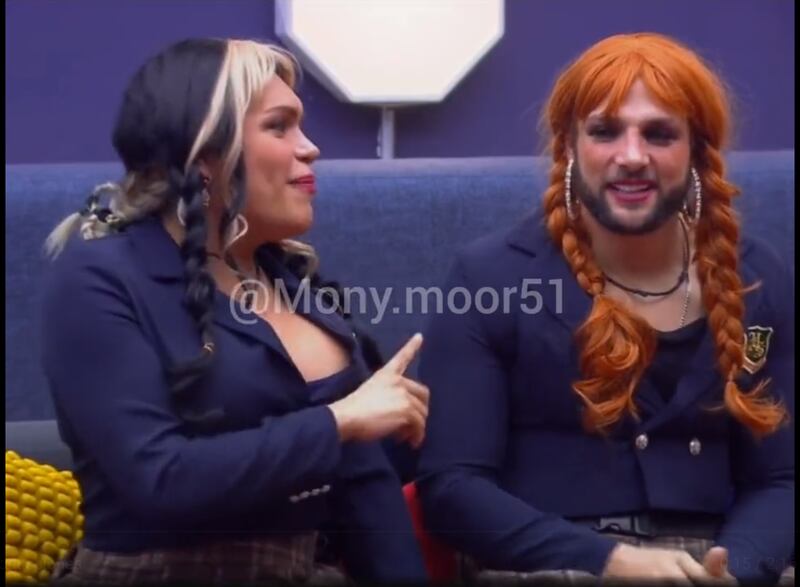 Dos personas vestidas como colegialas, imitando a Belinda en "Cómplices al rescate": con pelucas, y unos trajes azul oscuro.